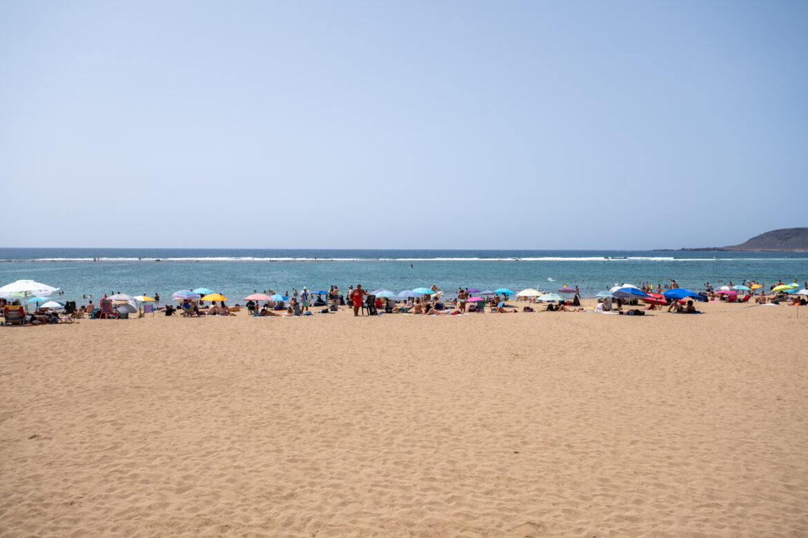Orilla de Las Canteras con sombrillas y el agua en calma
